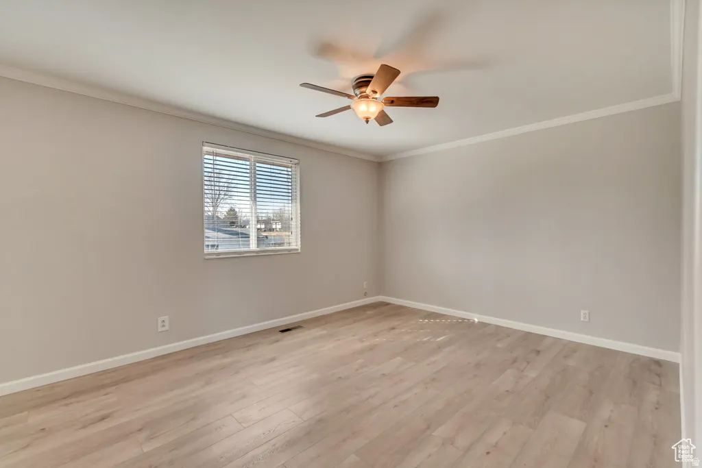 Unfurnished room with crown molding, light wood-type flooring, and ceiling fan