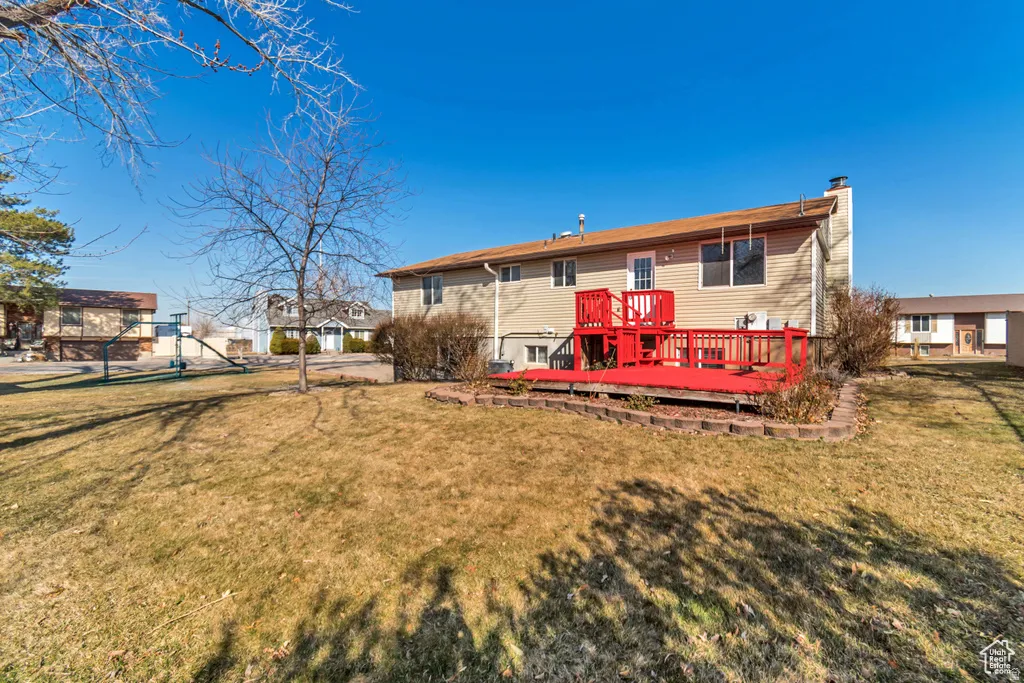 Back of property with a wooden deck and a chimney