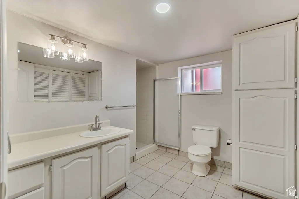 Bathroom featuring vanity, a stall shower, light tile patterned floors, and a closet