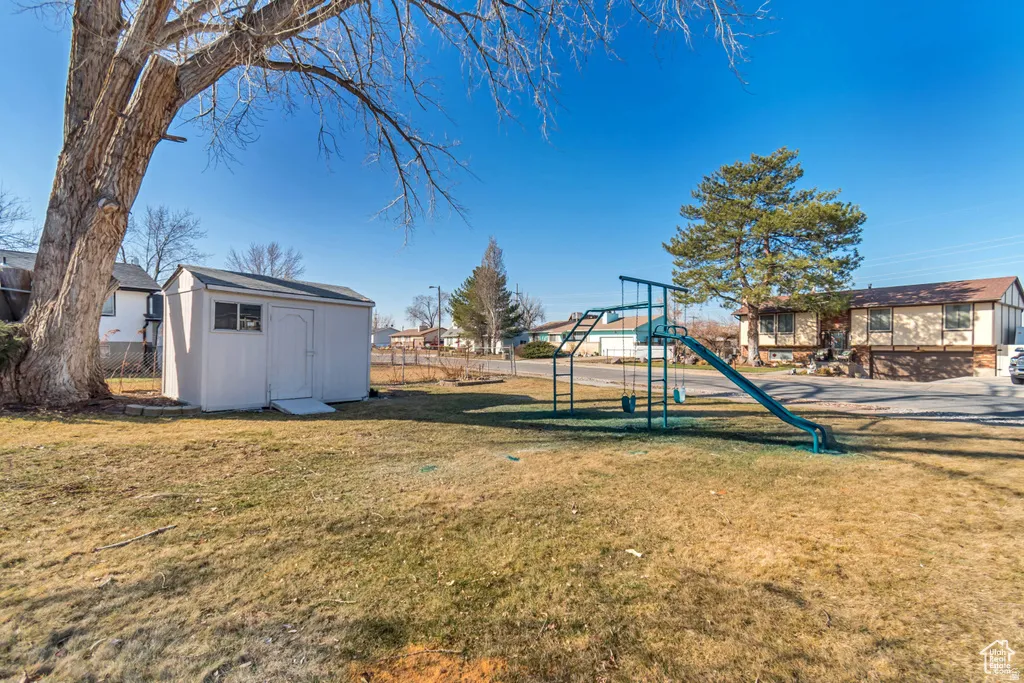 View of play area with a storage shed and a residential view