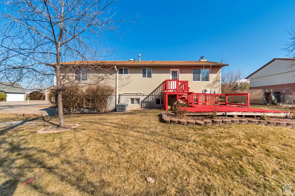 Rear view of property featuring a wooden deck and a chimney