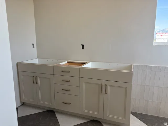 Light-toned vanity cabinetry featuring multiple drawers and cabinet doors with brushed nickel hardware