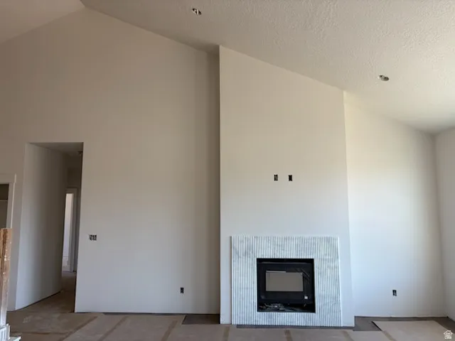 Vaulted ceilings complement a fireplace featuring a tile surround