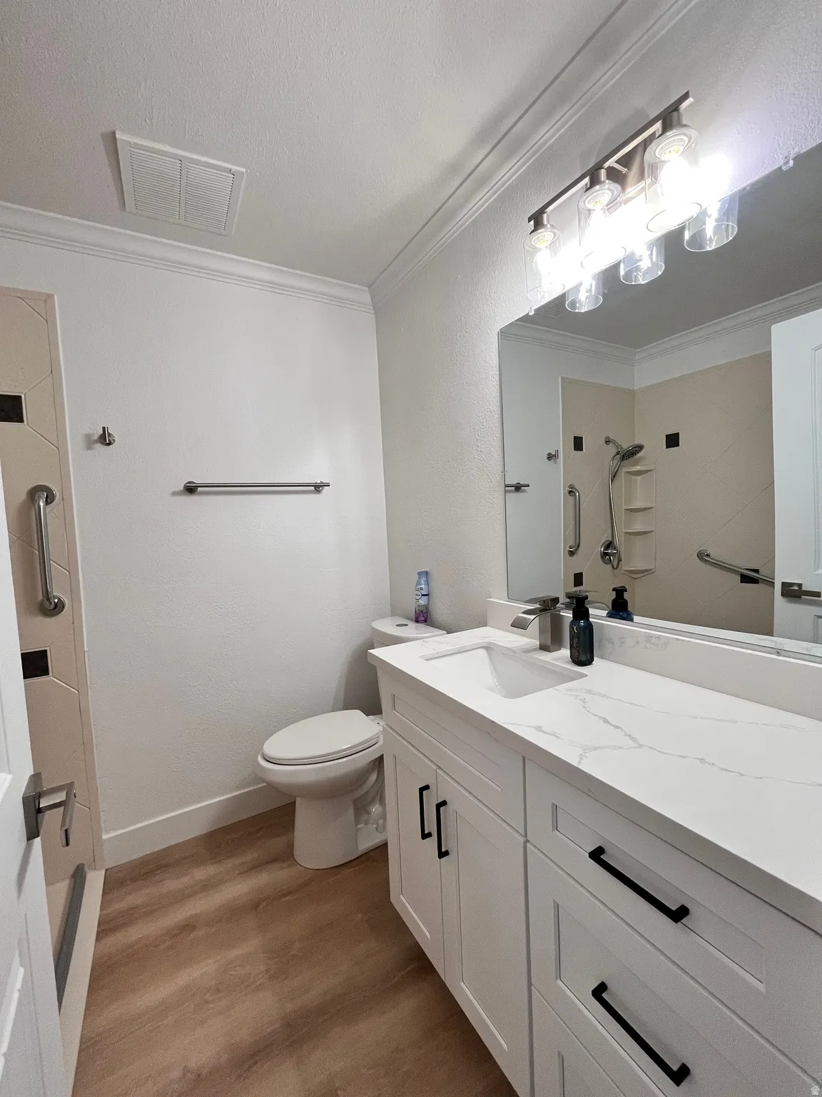 Bathroom featuring a double-door vanity with white cabinetry and black hardware, a rectangular undermount sink, and a white countertop with subtle veining