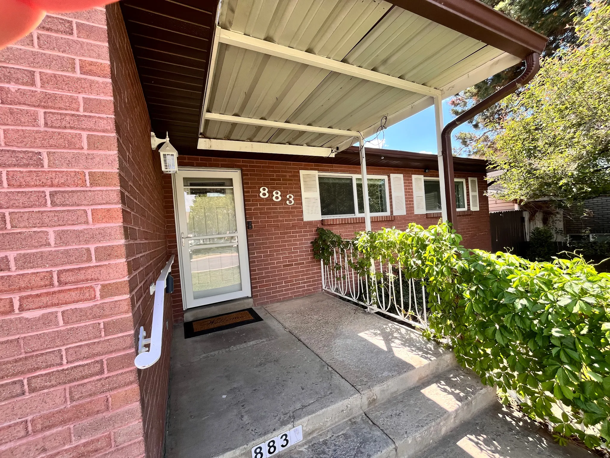 Brick exterior home featuring a covered front entry