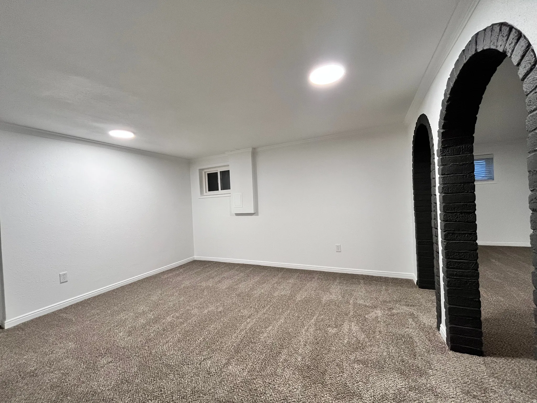 Expansive room featuring recessed lighting, a white painted finish, and crown molding