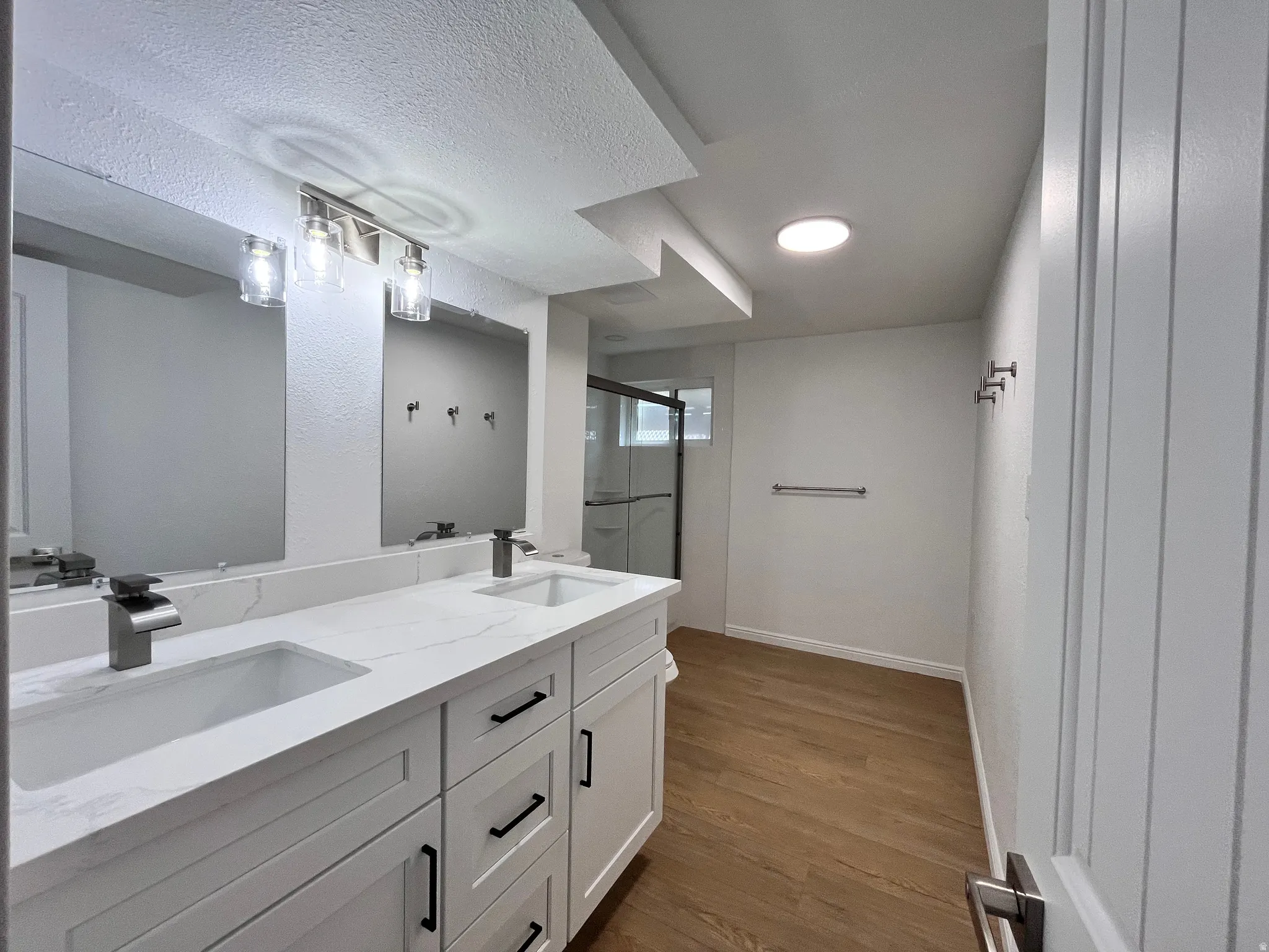 Contemporary bathroom featuring a double vanity with quartz countertops, undermount sinks, and modern faucets