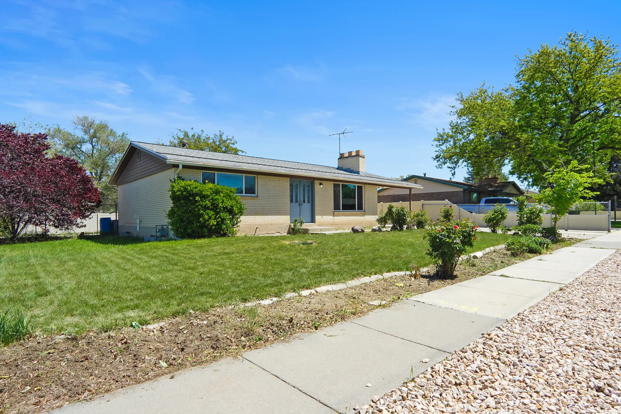 Ranch-style exterior featuring a neutral brick facade, complementary siding, and a gabled roof