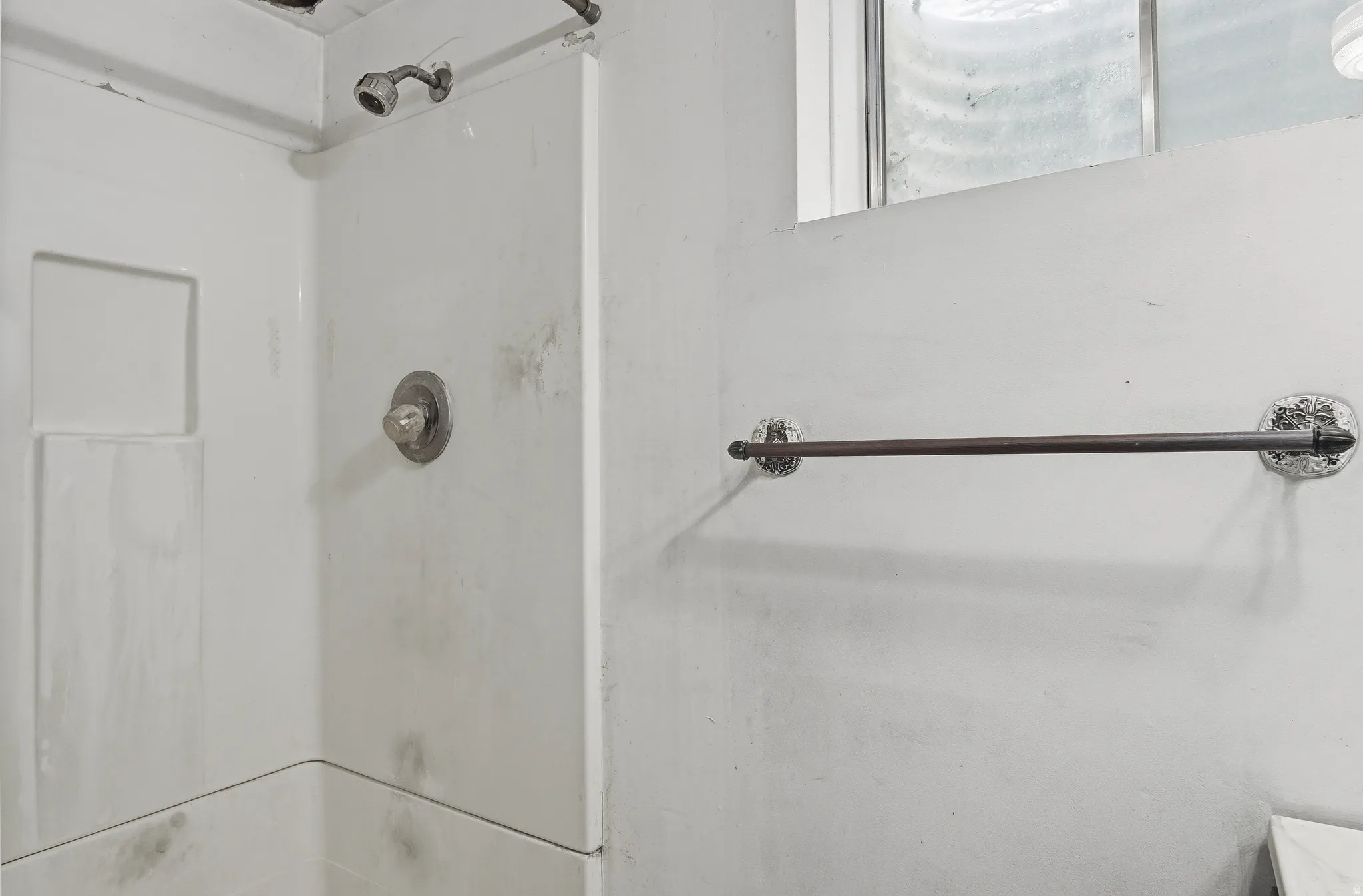 White shower stall with an integrated soap dish and a single-handle faucet