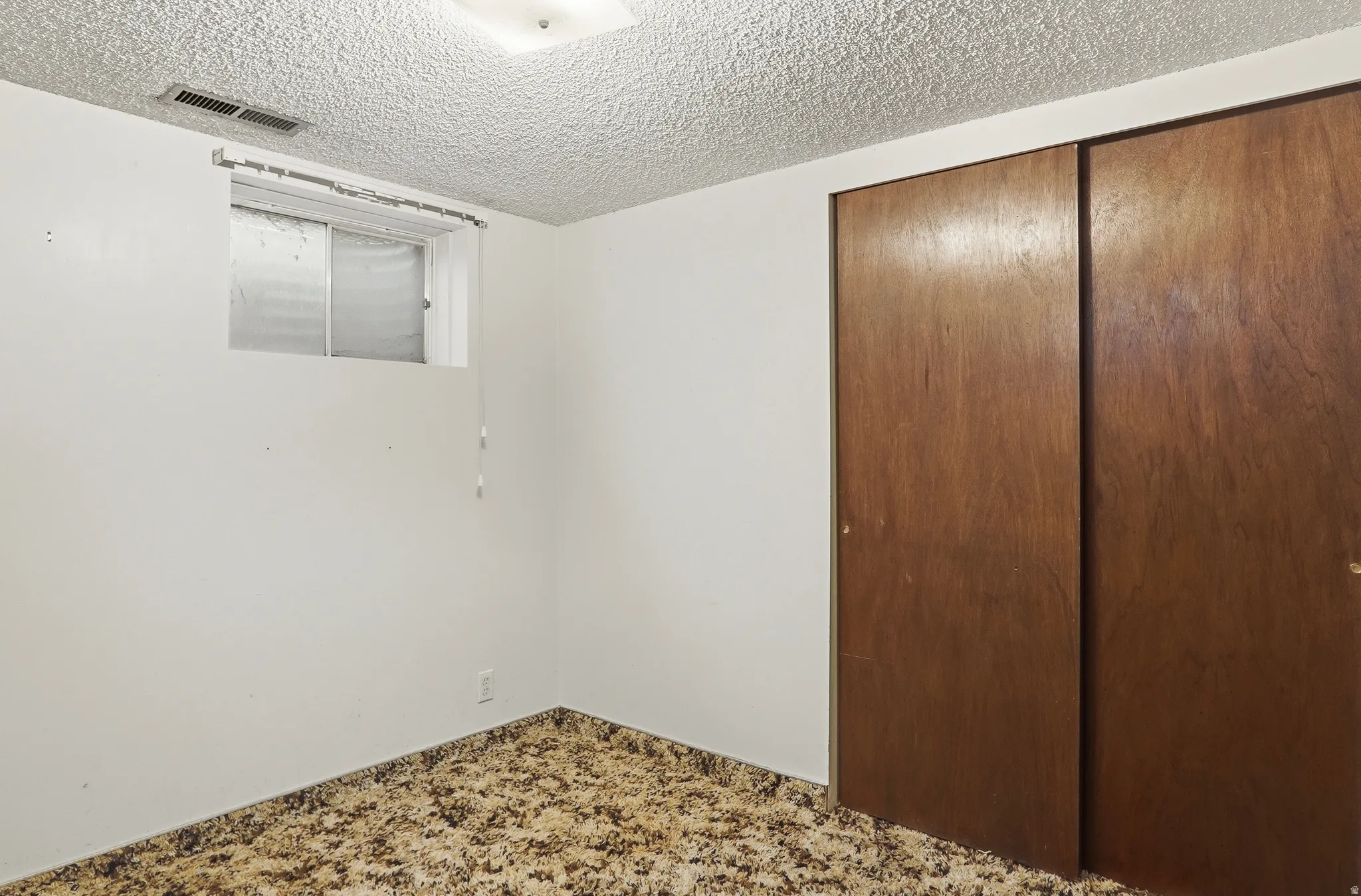 Room featuring white painted walls and a textured ceiling