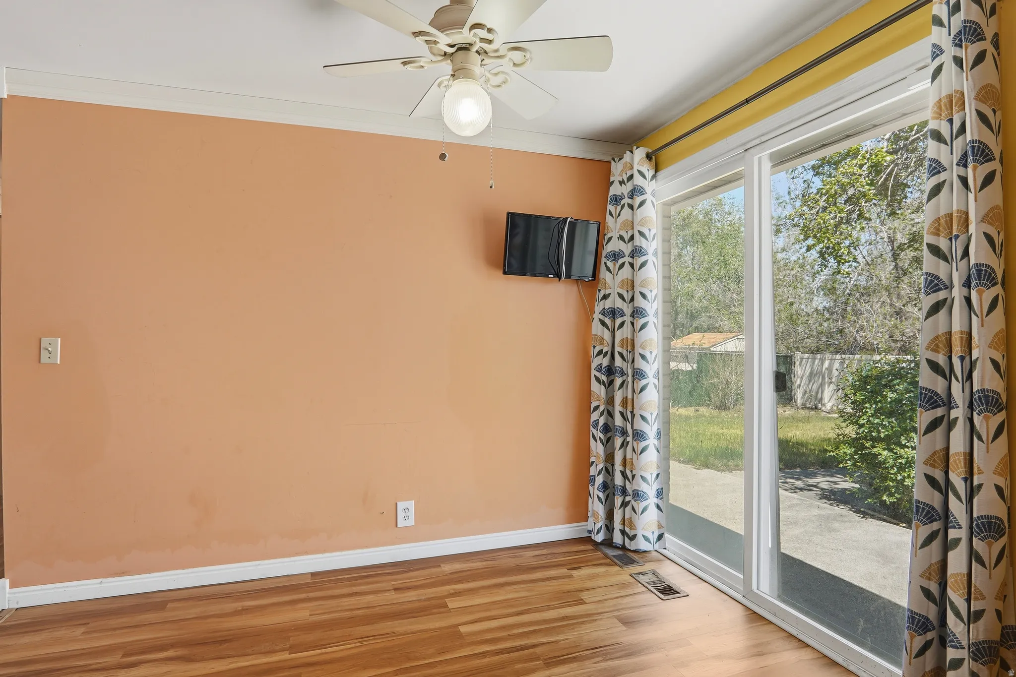 Sliding glass door opening to outdoor space, complemented by wood-finish flooring