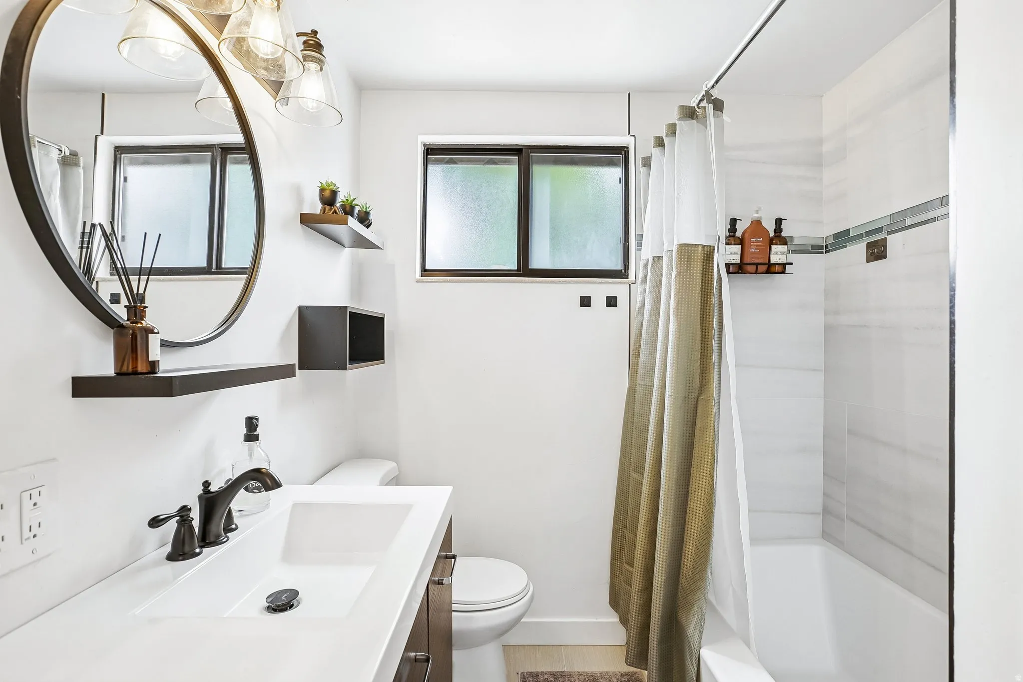 Modern bathroom featuring a vanity with an integrated rectangular sink, dark wood-finish cabinetry, and a black faucet