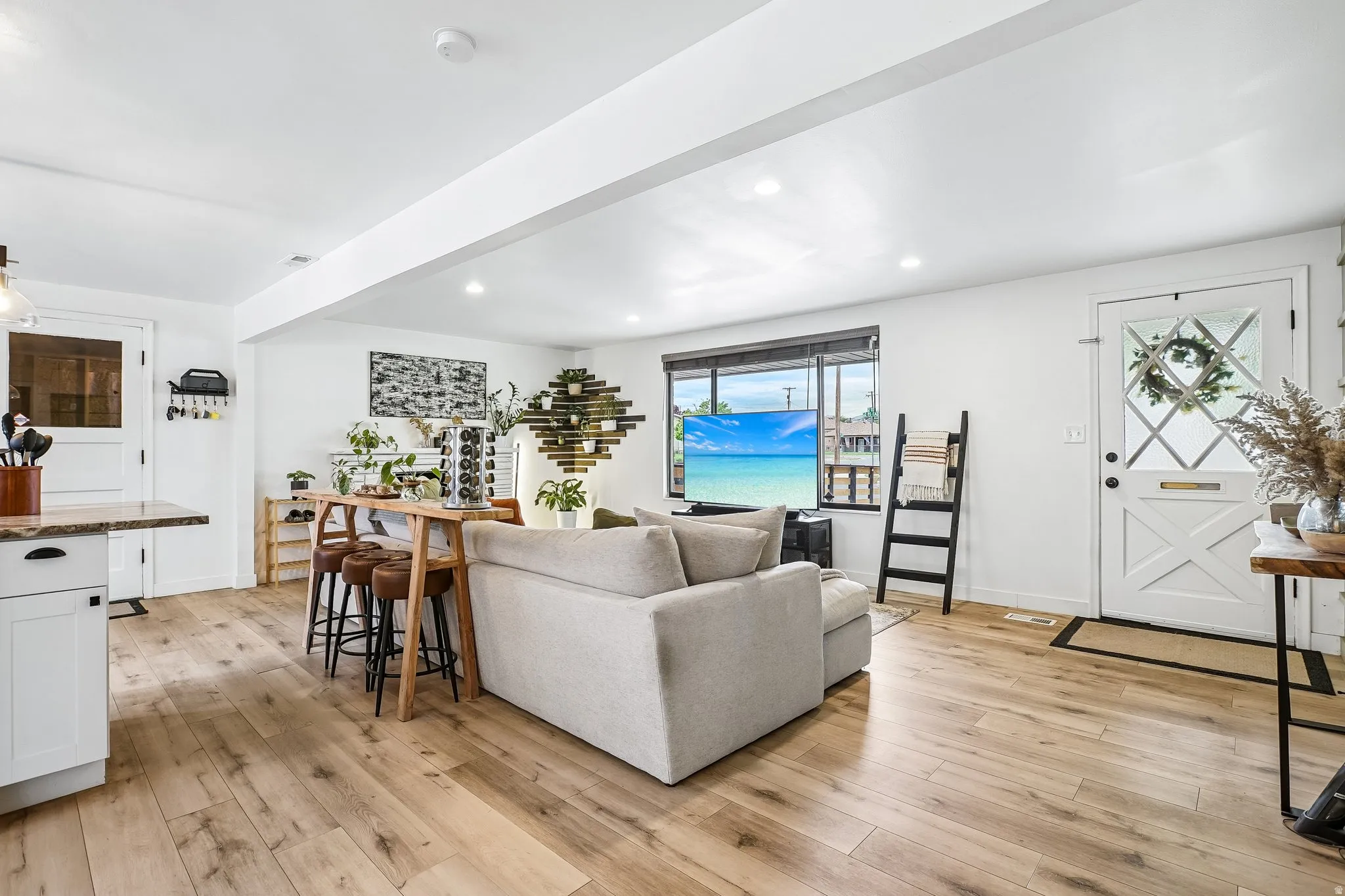 Open-concept living space featuring wide-plank wood-finish flooring, recessed lighting, and white walls