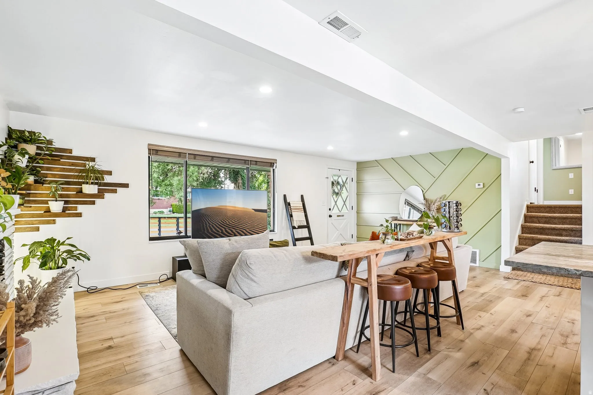 Spacious open-concept living area featuring wood-finish flooring and recessed lighting
