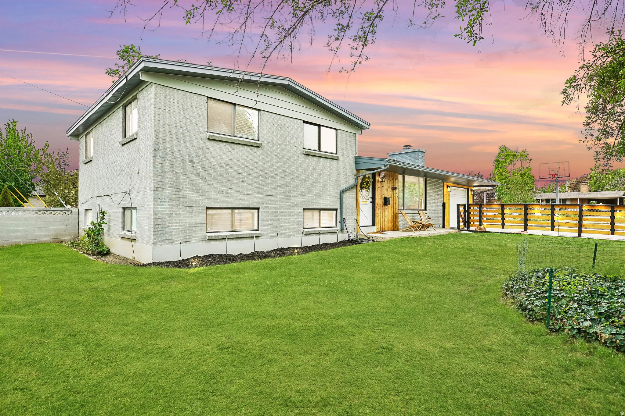 Expansive green lawn with a two-story residence featuring light gray brick siding