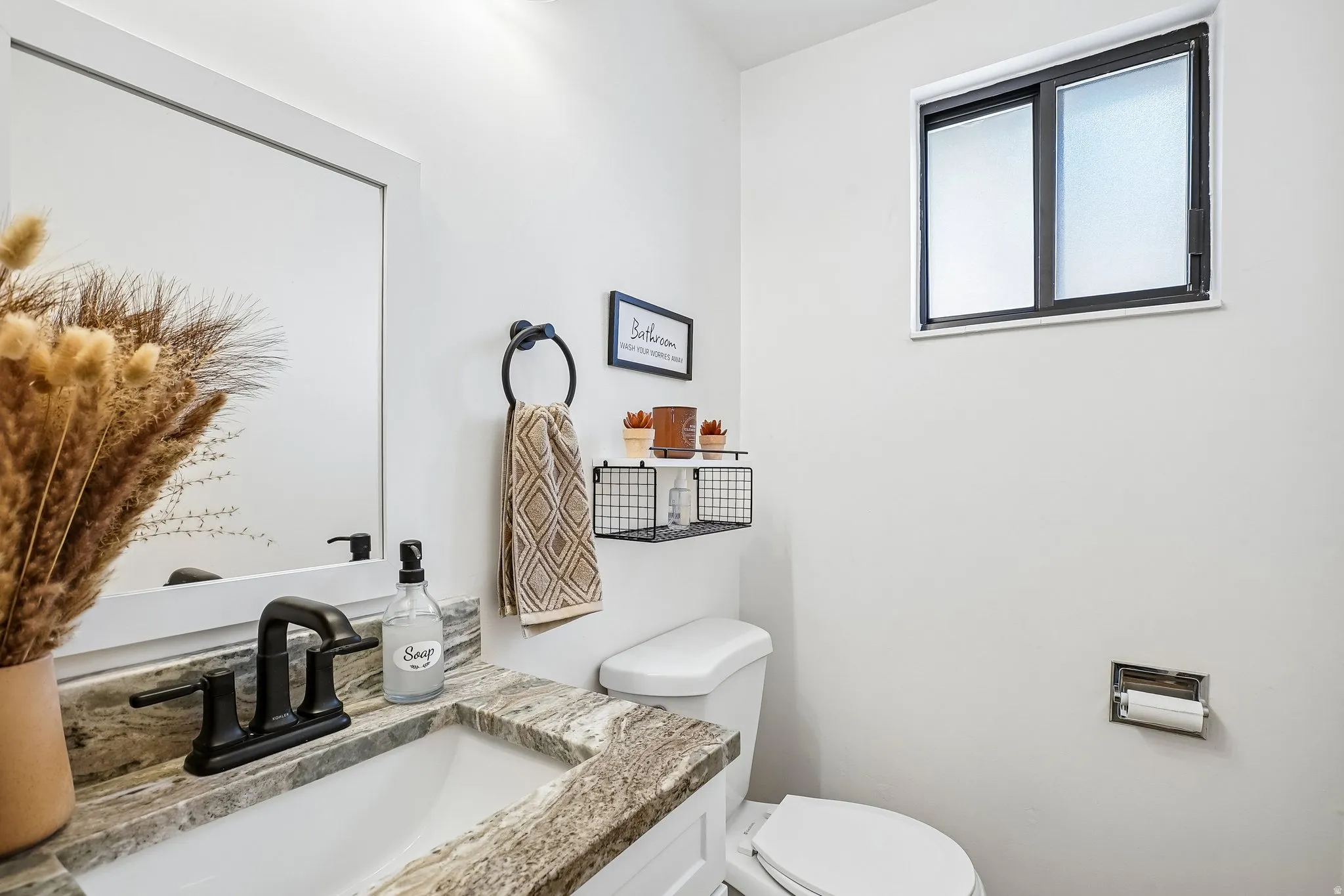 Vanity featuring a stone countertop, an undermount sink, and a matte black faucet