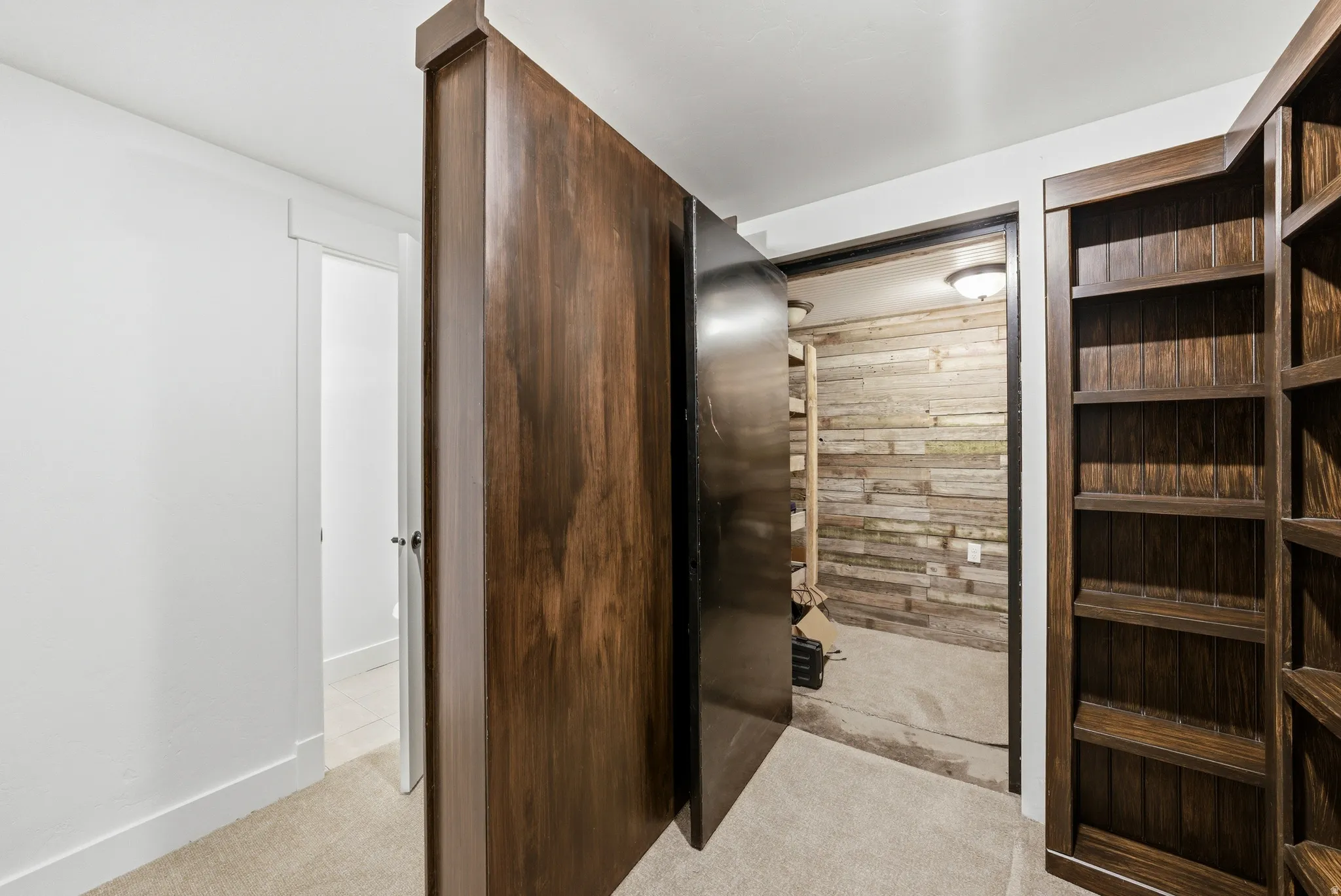 Built-in wooden bookcase with deep shelving, featuring a hidden access door crafted from matching wood