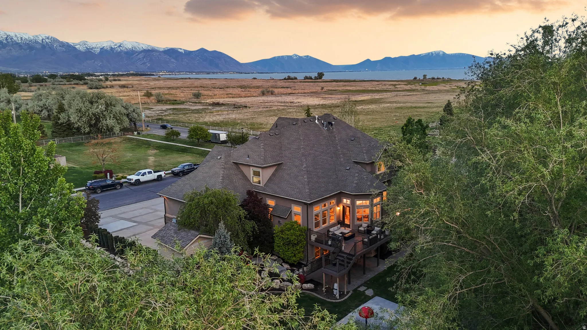 Spacious residence with a multi-level deck, dark shingle roofing, and a prominent bay window