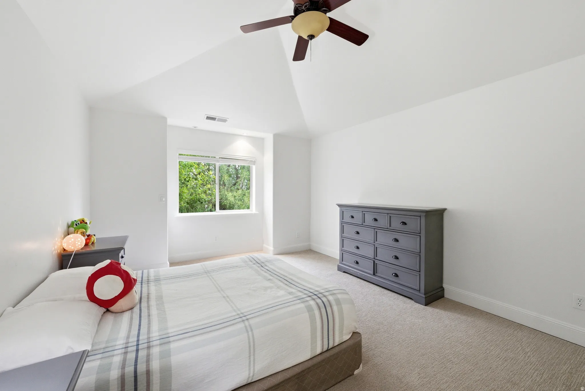 Bright room featuring a vaulted ceiling and window providing natural light