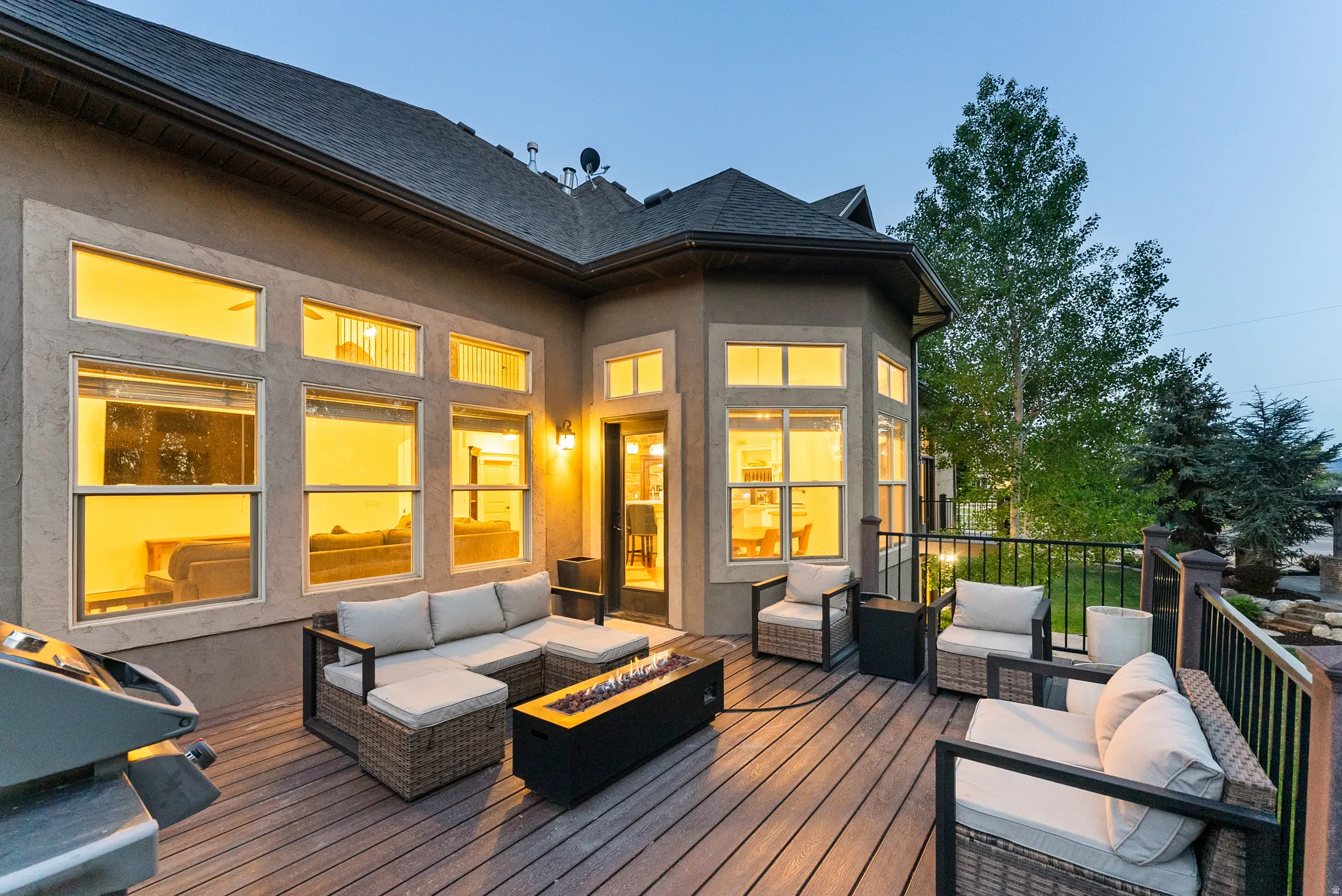 Spacious elevated deck featuring composite decking, dark railings, and a built-in fire pit