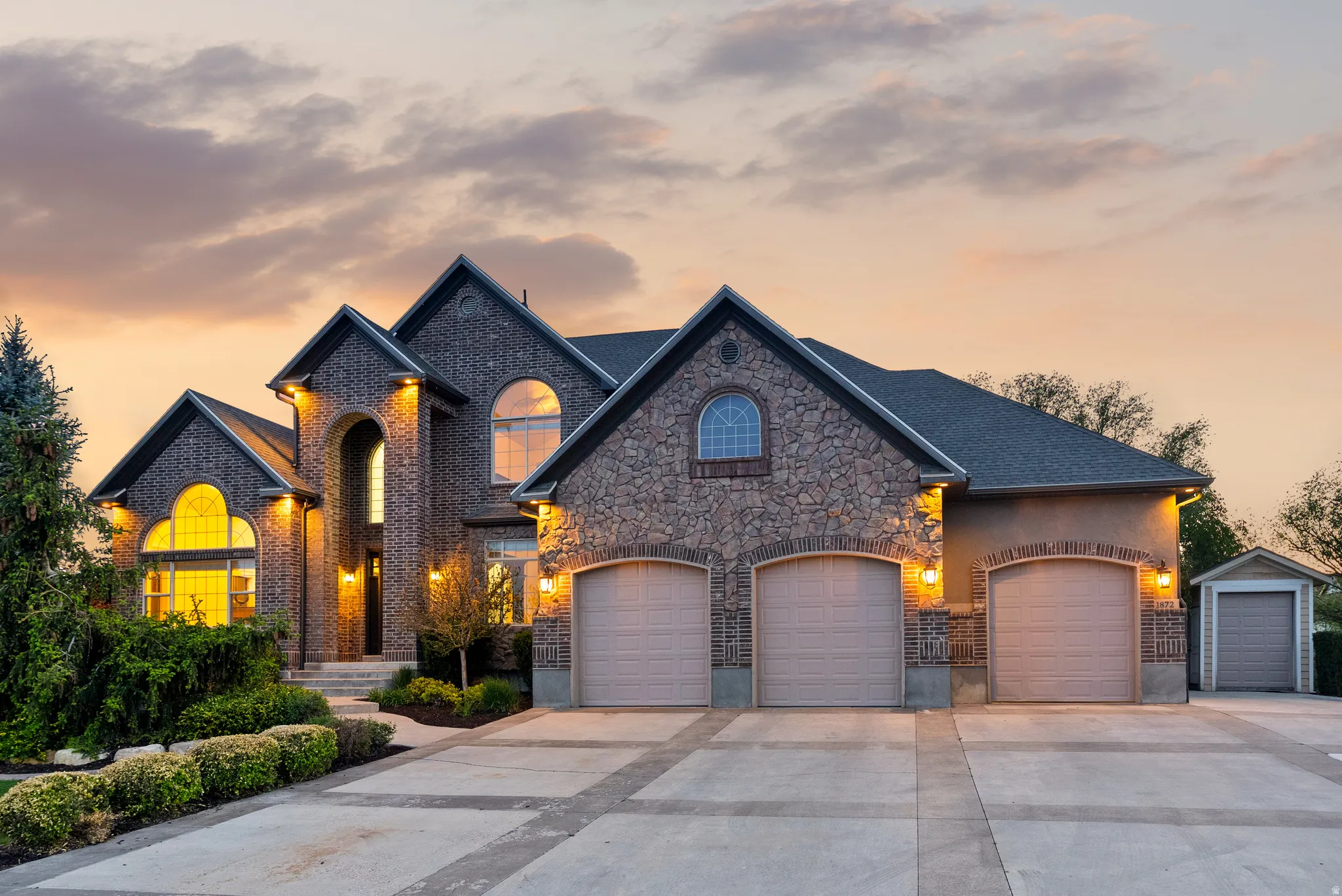 Brick and stone facade residence featuring multiple gables and arched window designs