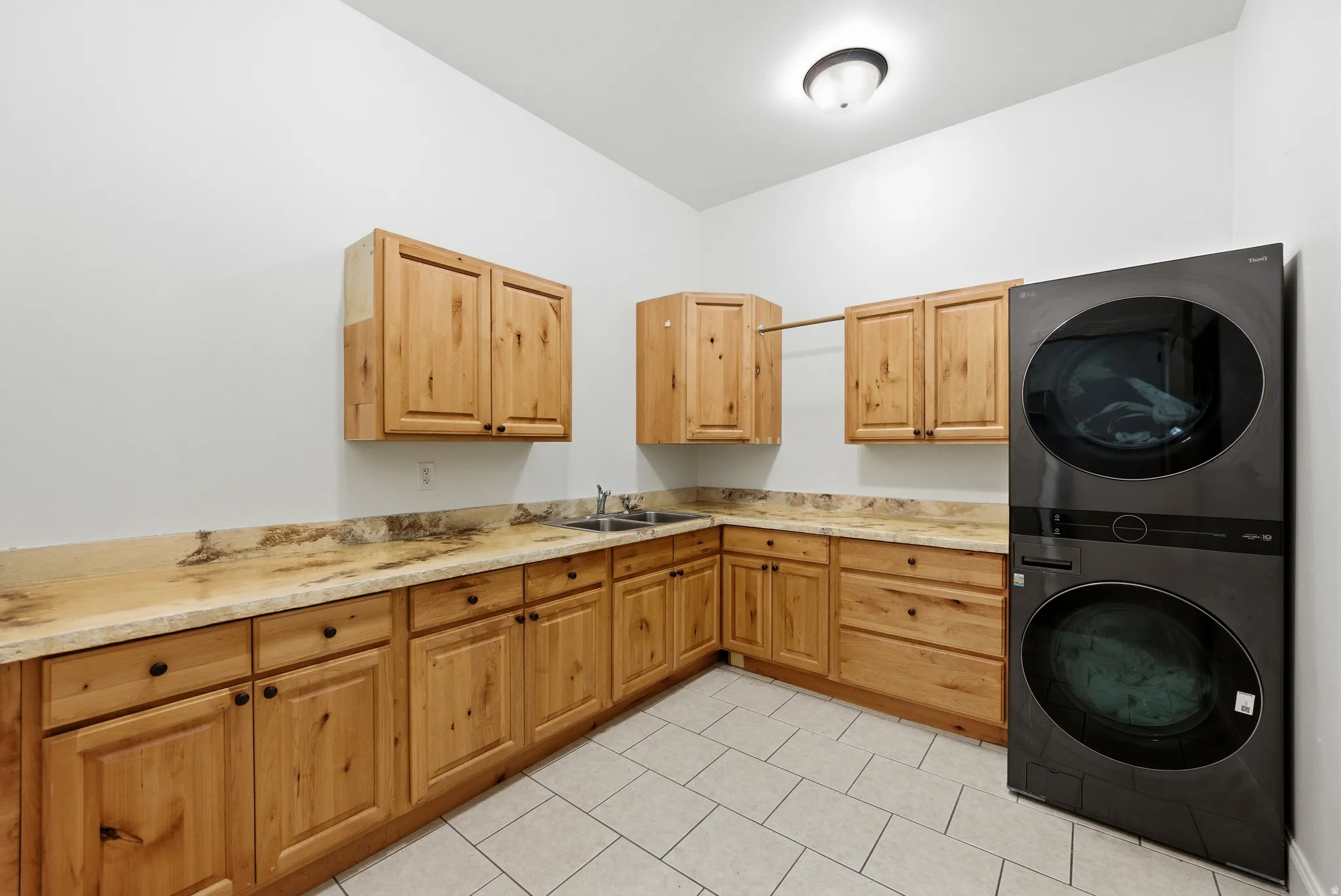 Utility room featuring a built-in sink, extensive wood cabinetry, and solid surface countertops