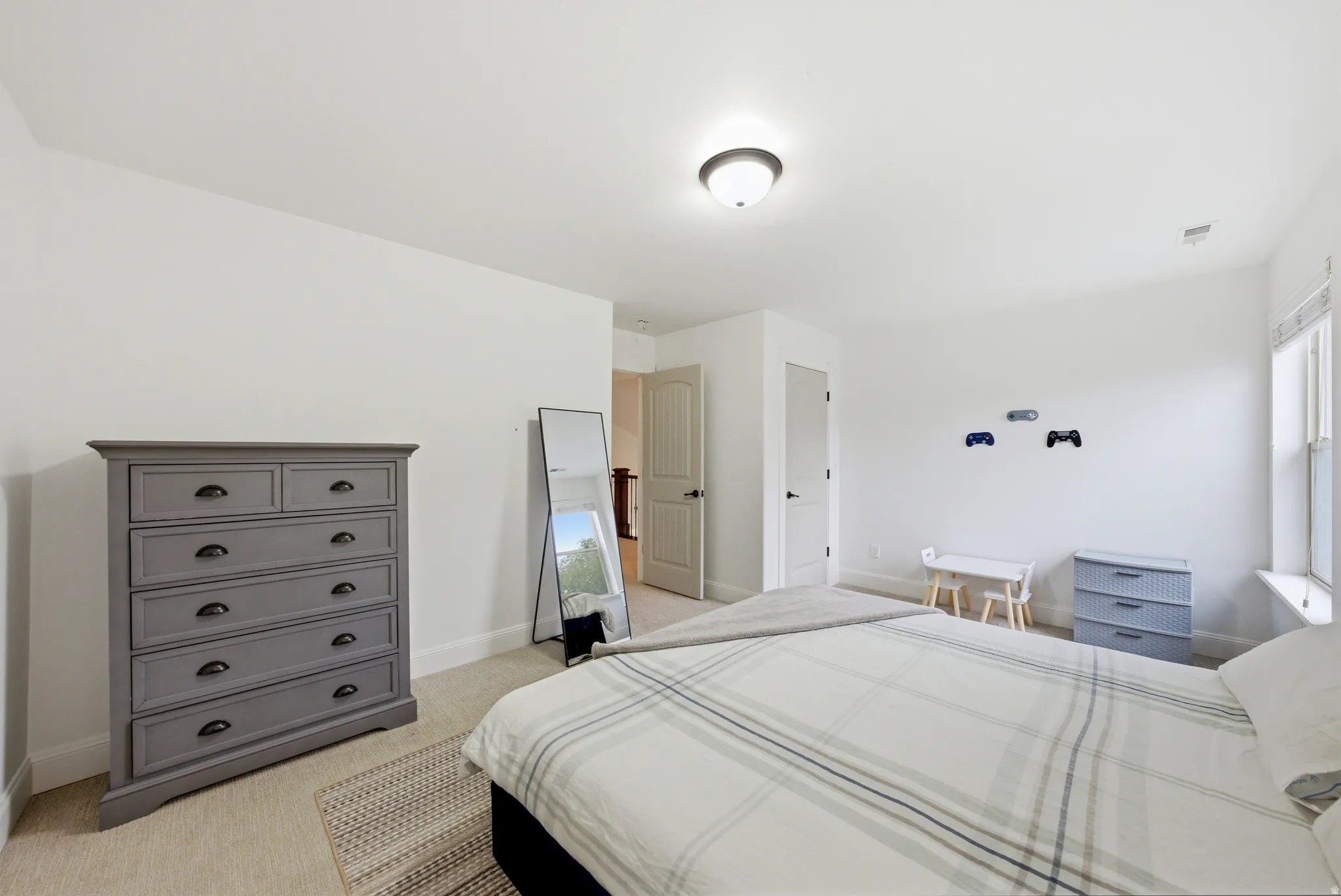 Bedroom featuring neutral wall paint, carpet flooring, a window with blinds, and two interior doors