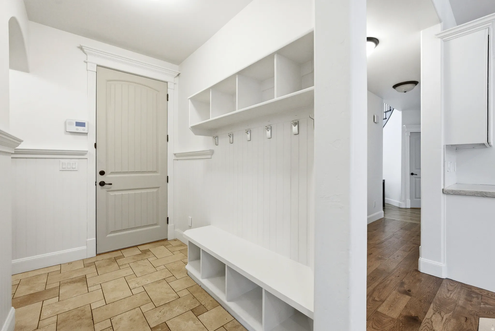 Mudroom entry featuring built-in bench seating, cubby storage, and coat hooks
