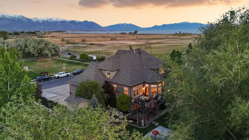 Spacious residence with a multi-level deck, dark shingle roofing, and a prominent bay window
