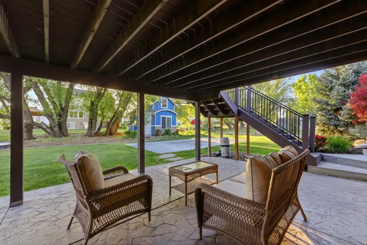 Covered patio with stamped concrete flooring, supported by a finished wooden beam structure