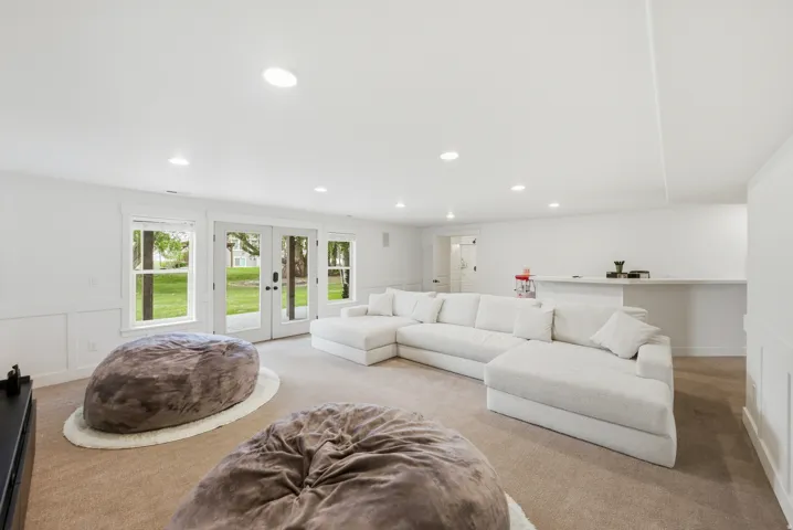 Spacious entertainment room featuring recessed lighting, a built-in bar, and carpet flooring