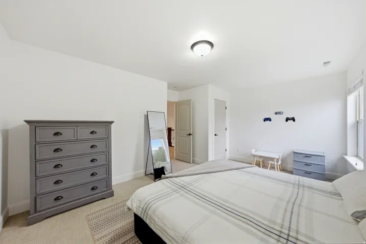 Bedroom featuring neutral wall paint, carpet flooring, a window with blinds, and two interior doors