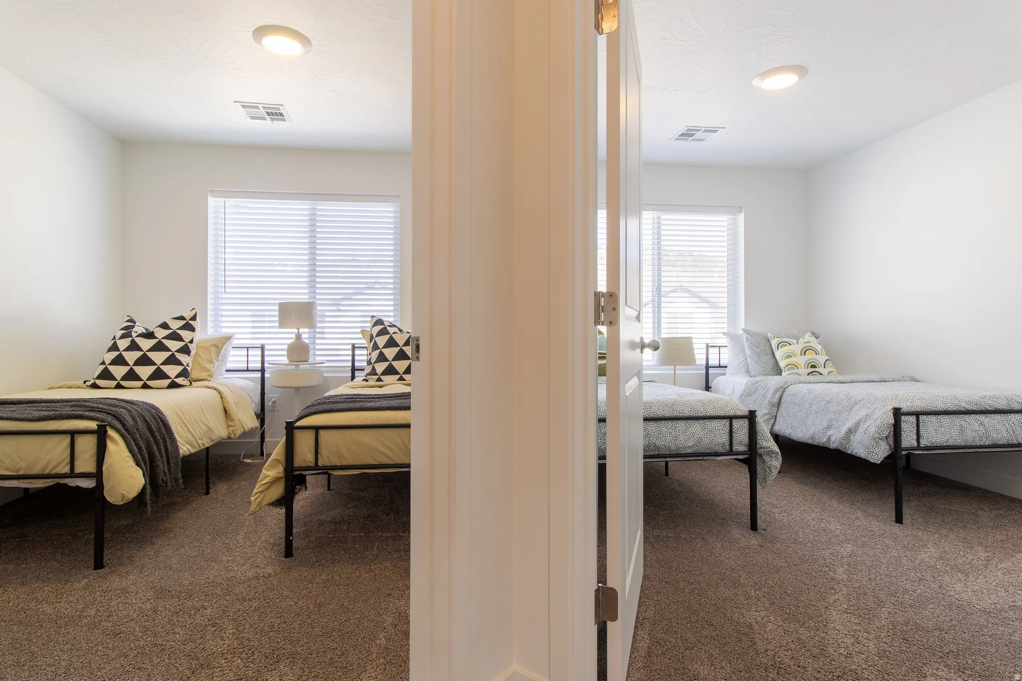 These two separate rooms feature light neutral paint, recessed lighting, and soft carpet flooring, creating a bright and comfortable space that can easily be used as bedrooms, offices, or flex rooms