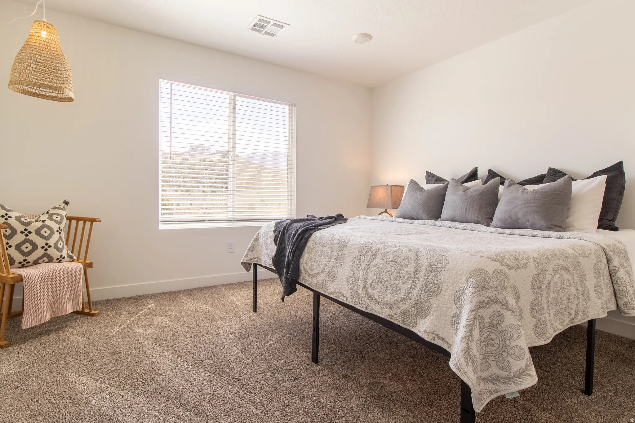 Spacious primary bedroom featuring recessed lighting, a large window that fills the space with abundant natural light, a private ensuite bath, and neutral carpet flooring