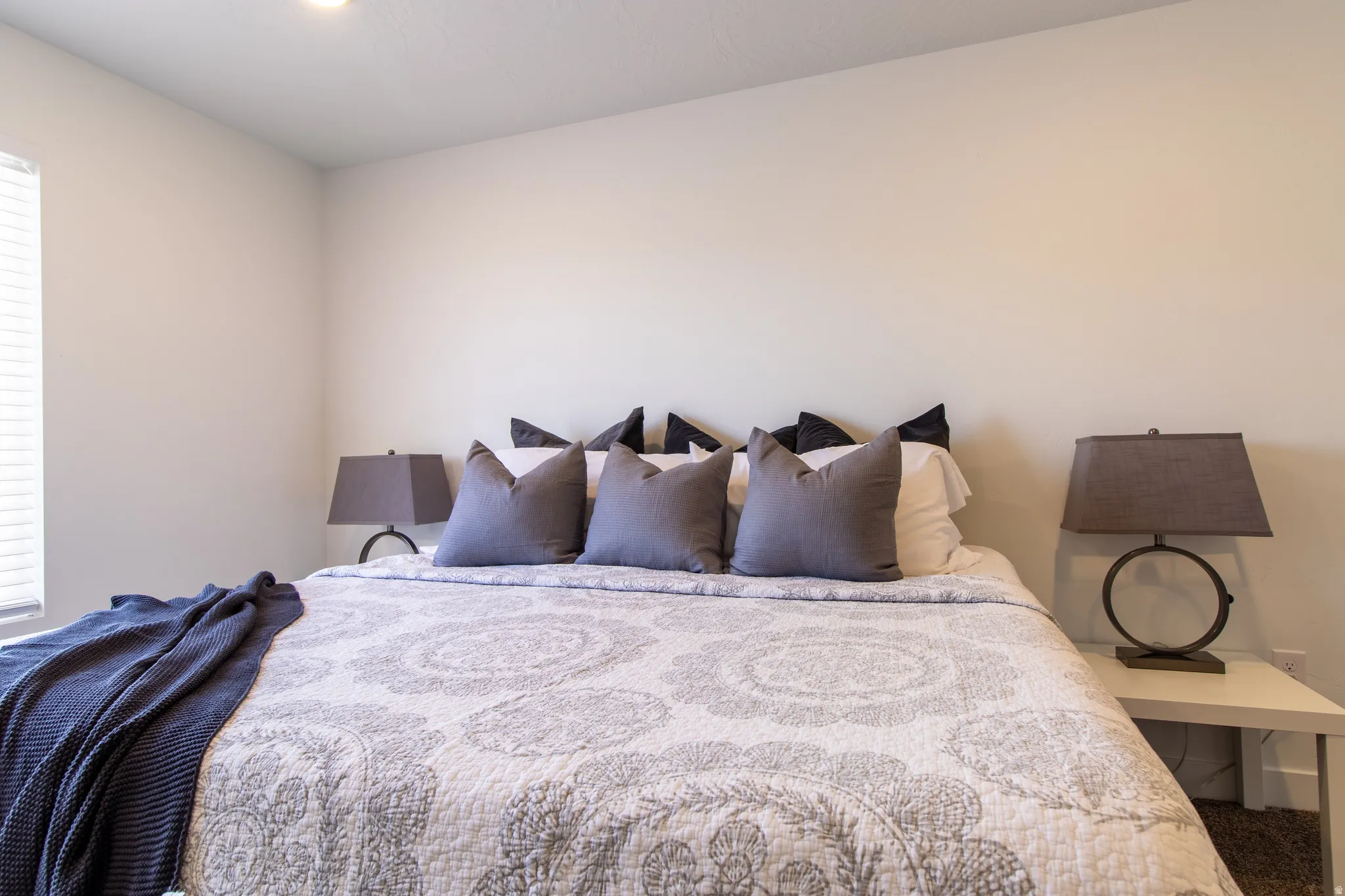 Spacious primary bedroom featuring recessed lighting, a large window that fills the space with abundant natural light, a private ensuite bath, and neutral carpet flooring