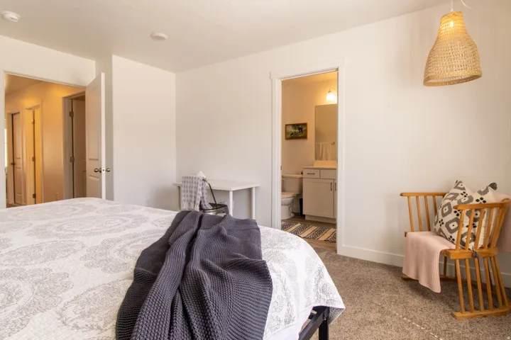 Spacious primary bedroom featuring recessed lighting, a large window that fills the space with abundant natural light, a private ensuite bath, and neutral carpet flooring