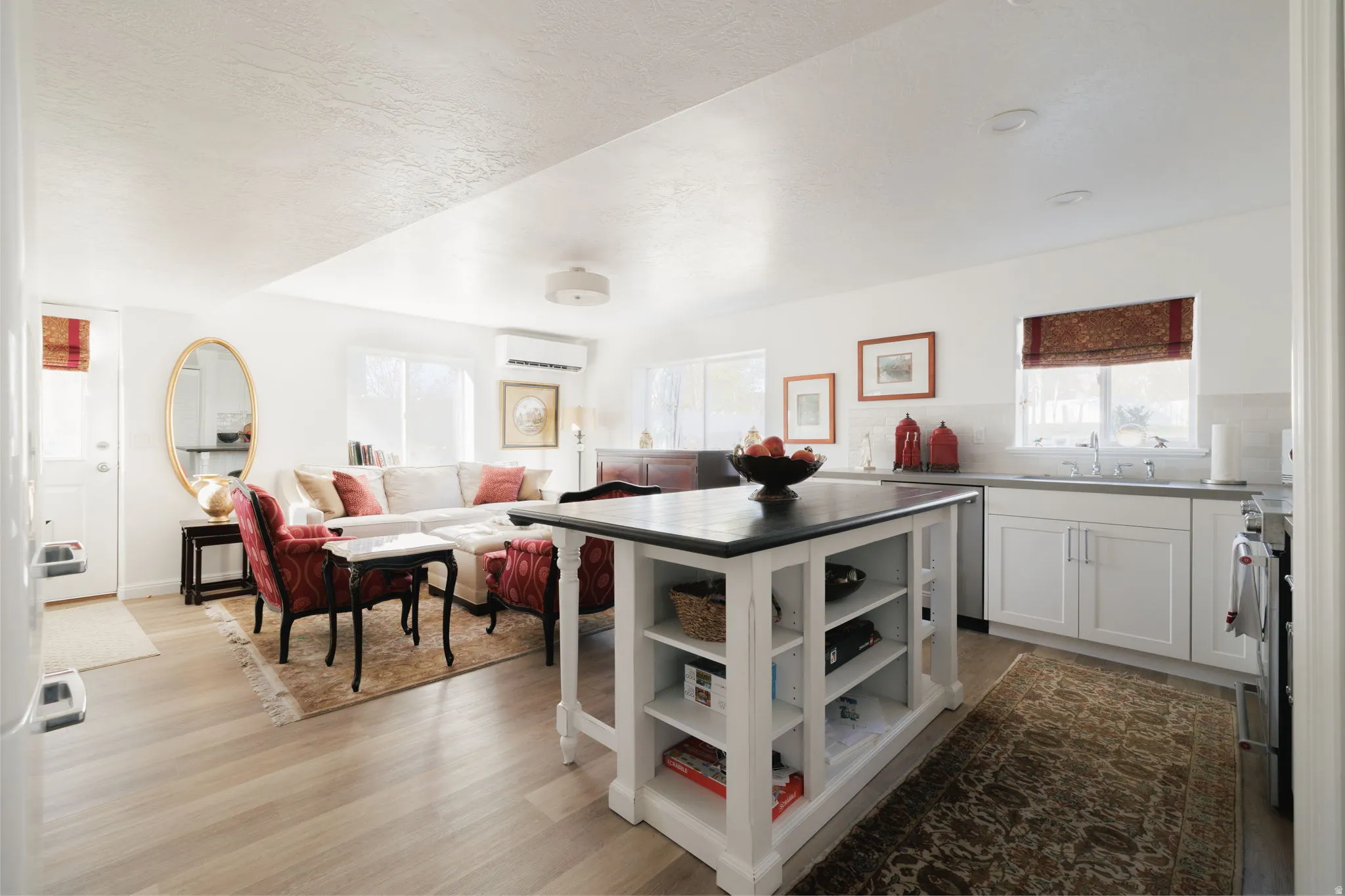 Kitchen with a kitchen island, white cabinets, light wood-style flooring, open floor plan, and open shelves