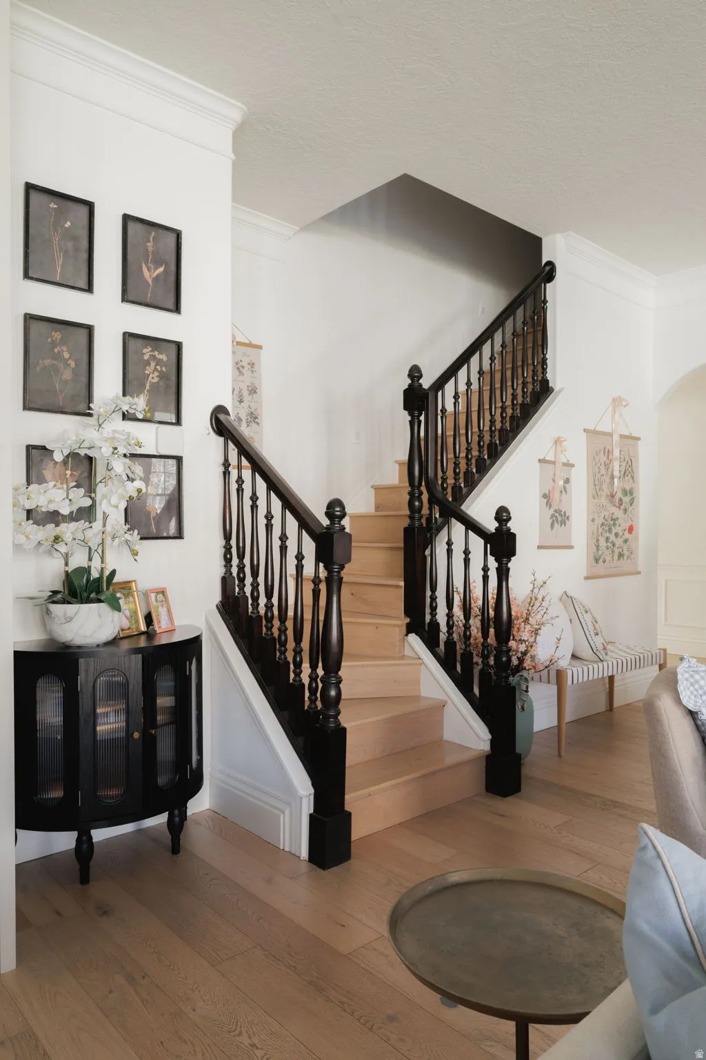 Stairway featuring ornamental molding, wood-type flooring, and arched walkways