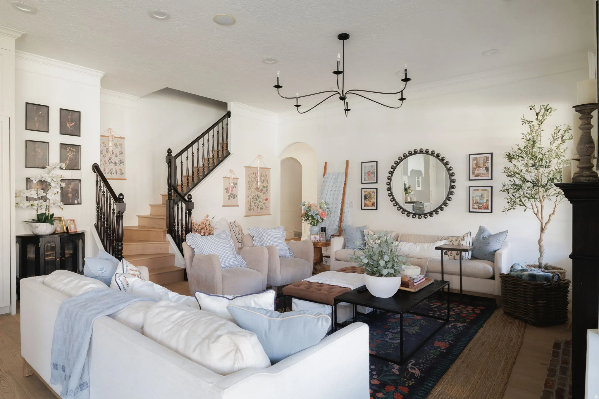 Living area with arched walkways, wood finished floors, and ornamental molding