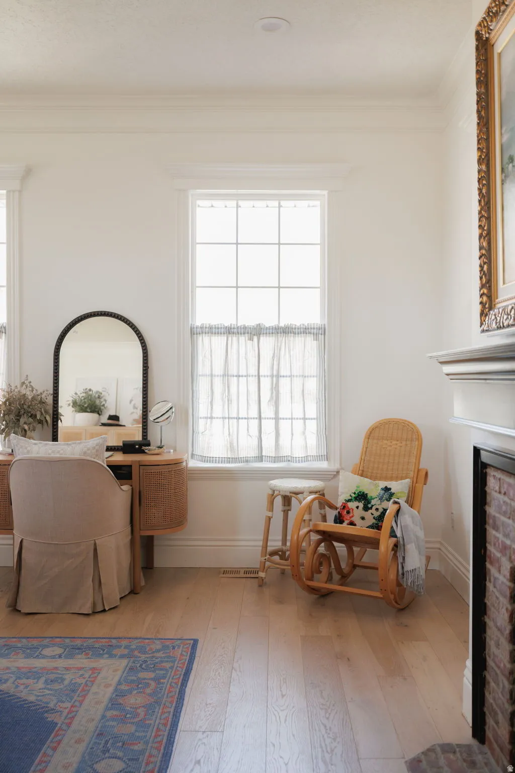 Living area featuring light wood-style flooring, a brick fireplace, and ornamental molding