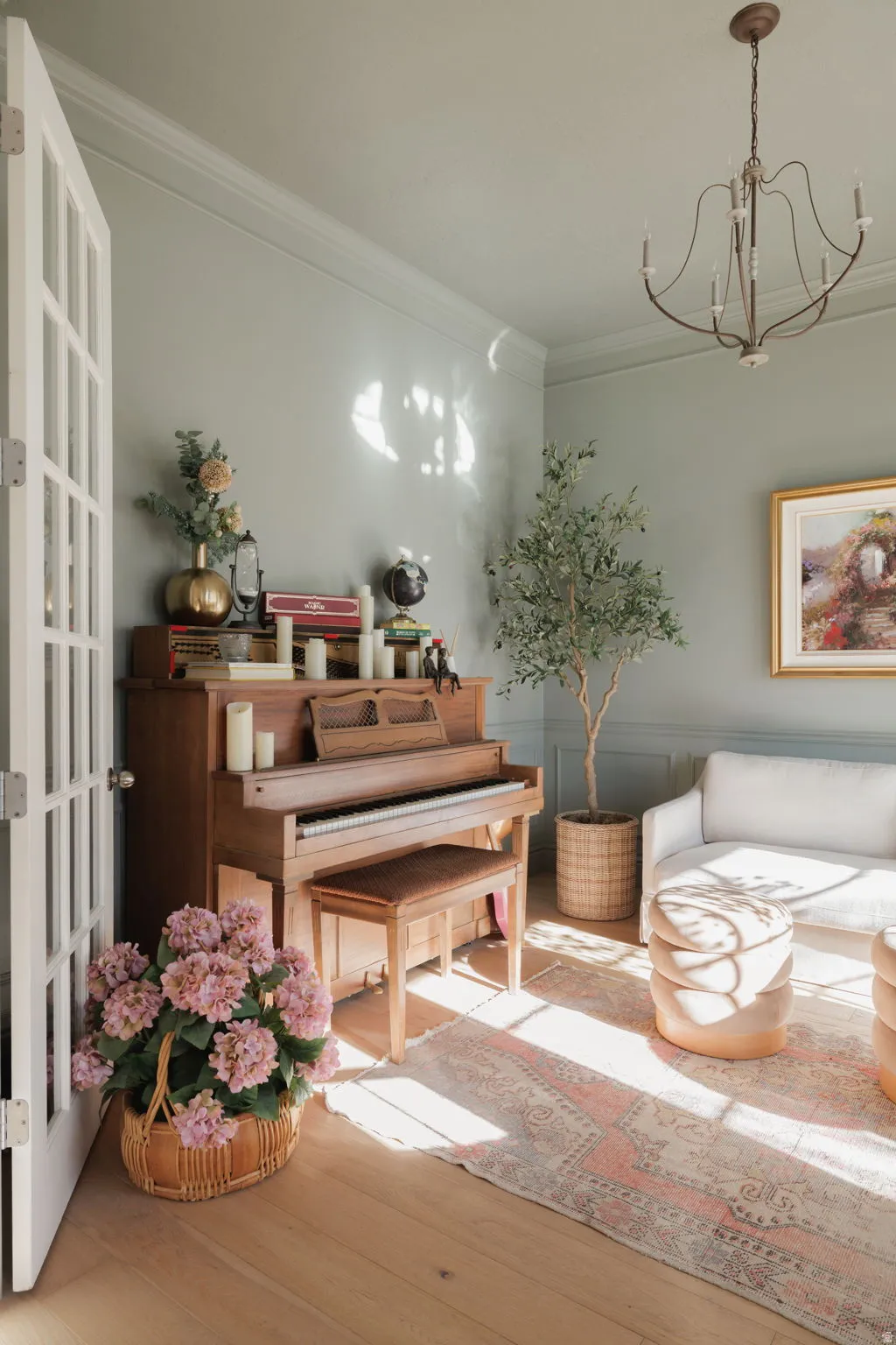 Living area featuring ornamental molding, hanging lights, and light wood-type flooring