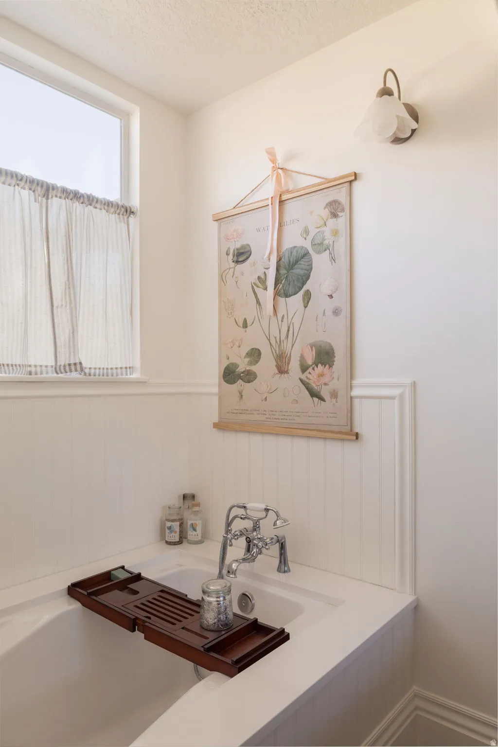 Bathroom featuring a wainscoted wall and a textured ceiling