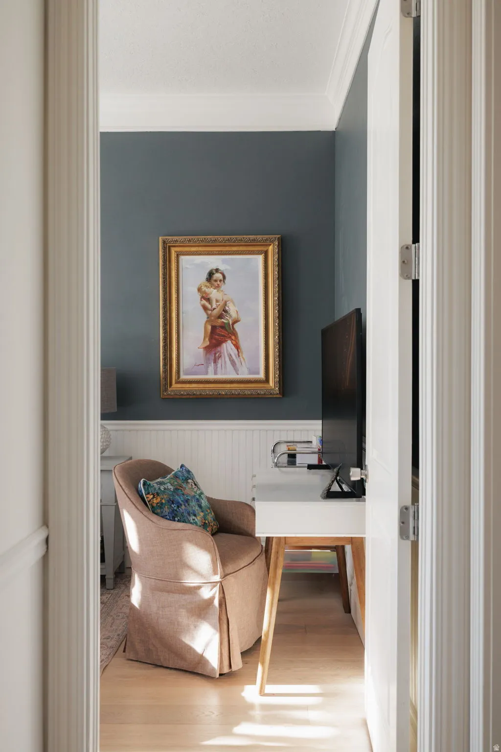 Office area featuring wainscoting, ornamental molding, and light wood-style floors