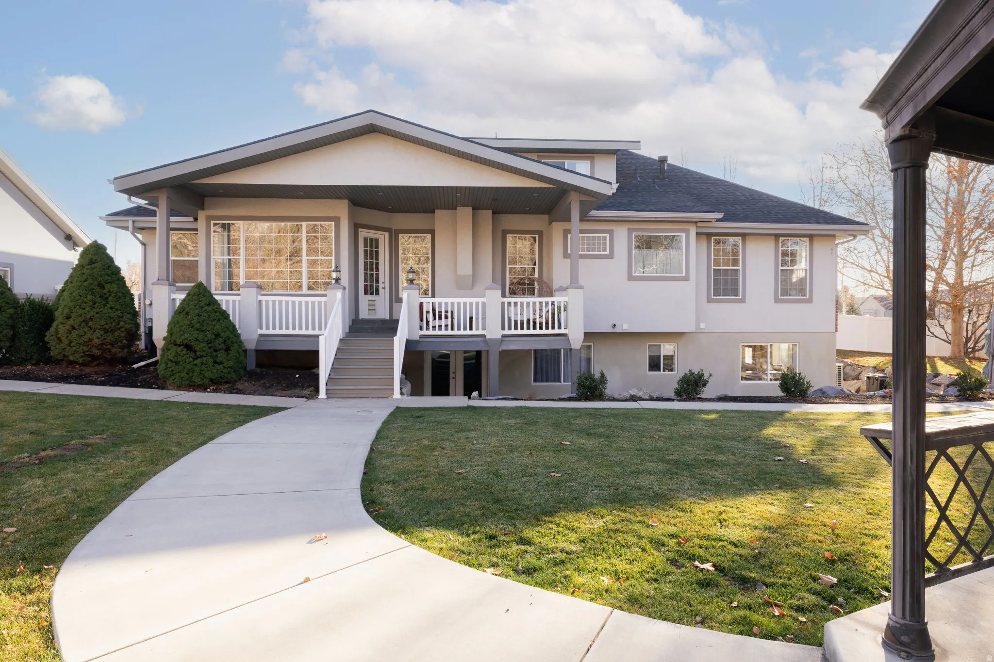 View of front of home with covered porch, stucco siding, and a front lawn