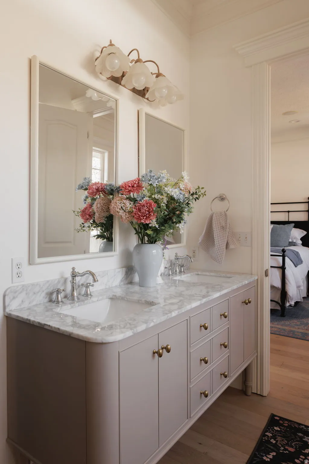 Ensuite bathroom featuring double vanity and light wood-style flooring