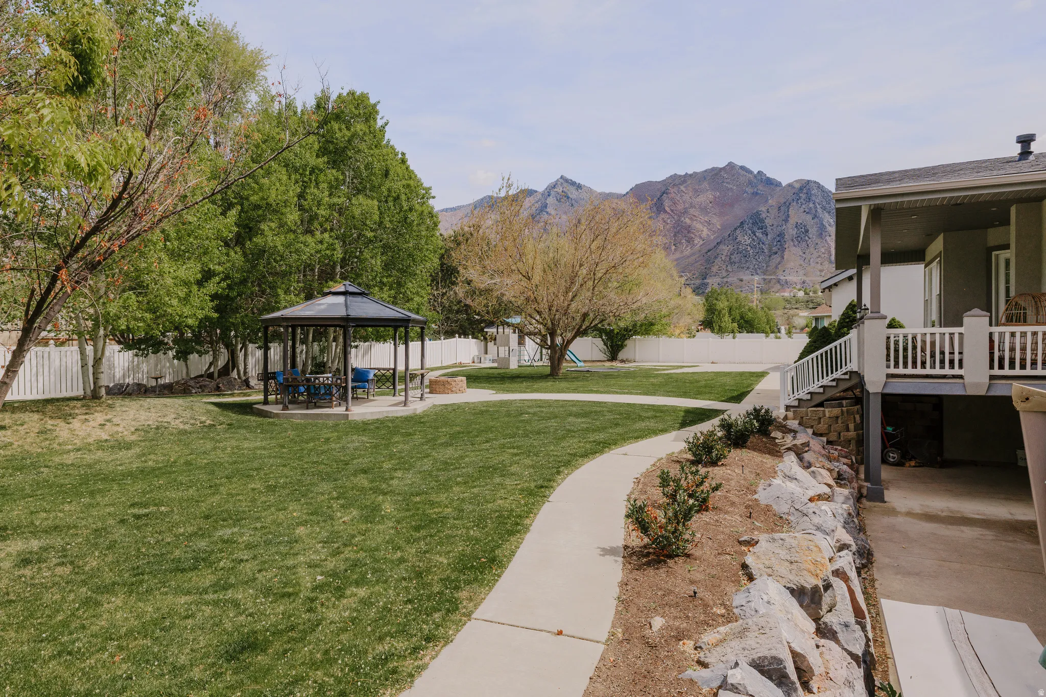 Fenced backyard featuring a mountain view, a patio area, and a gazebo