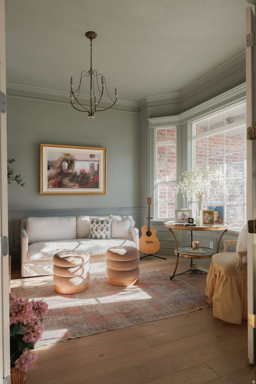 Living room with hardwood / wood-style flooring, a chandelier, ornamental molding, and wainscoting