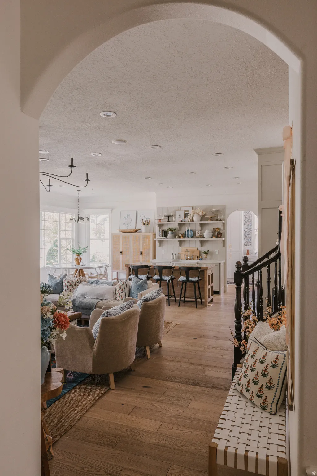Living room with arched walkways, dark wood-style flooring, and a textured ceiling