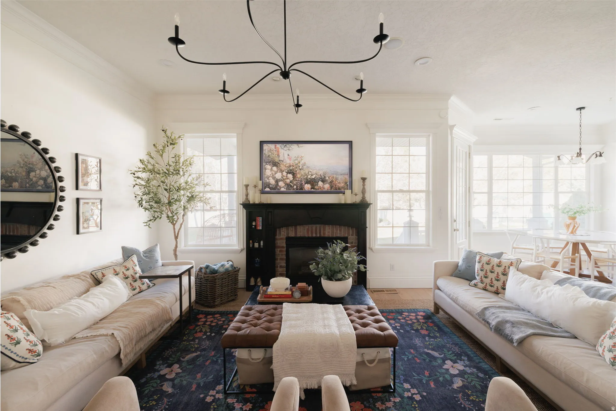 Living room with hanging lights, a fireplace, and crown molding