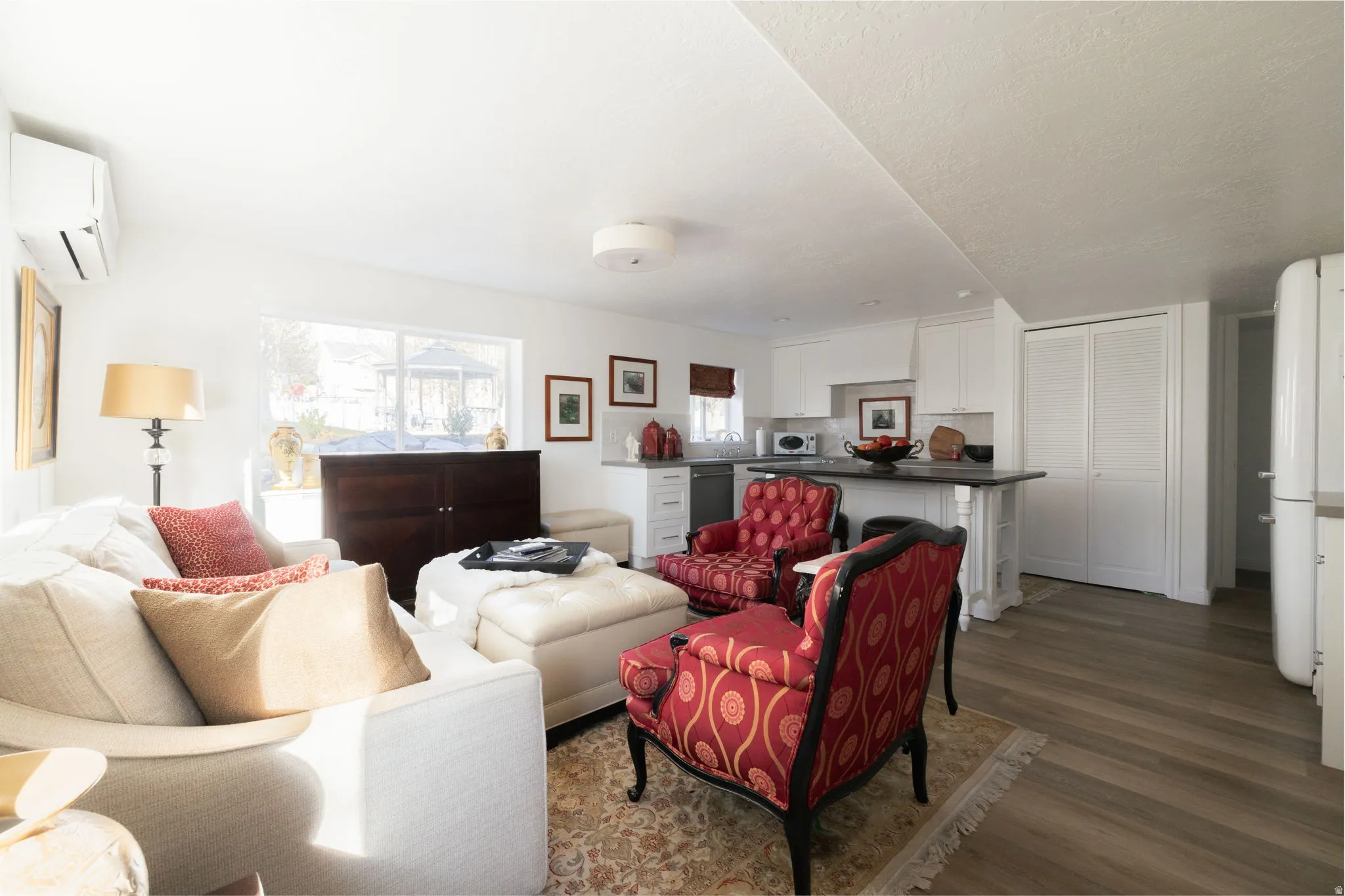 Living room with dark wood-type flooring and a mini split for heating / cooling